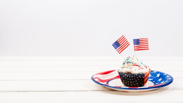 Apetitoso cupcake en plato con banderas americanas