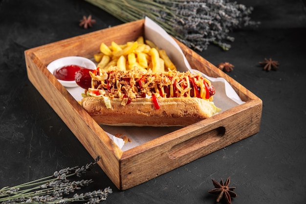 Apetitoso hot dog con virutas de cebolla y patatas fritas