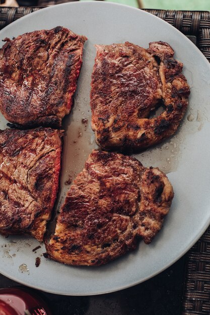 Apetitoso medio filete fresco a la parrilla asado en un plato blanco rodeado de hierba verde