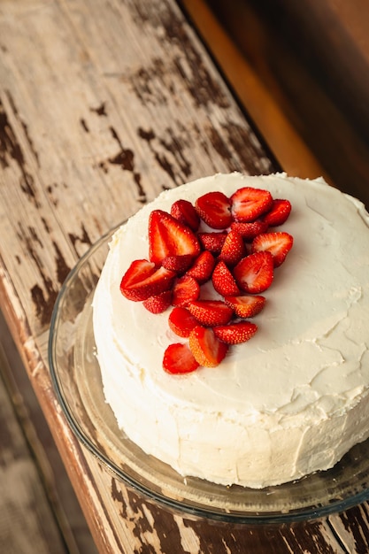 Apetitoso pastel de fresa decorado con fresas frescas en una vista superior de fondo de madera