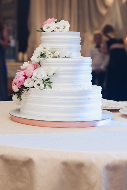 Foto apetitoso pastel de hojaldre fresco cubierto con glaseado de crema blanca y decorar dulce flor que sirve en la mesa