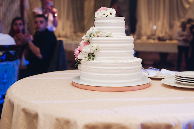 Foto apetitoso pastel de hojaldre fresco cubierto con glaseado de crema blanca y decorar dulce flor que sirve en la mesa