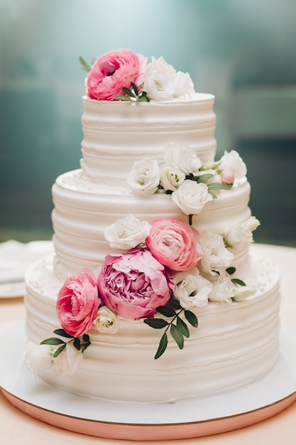 Apetitoso pastel de hojaldre fresco cubierto con glaseado de crema blanca y decorar dulce flor que sirve en la mesa