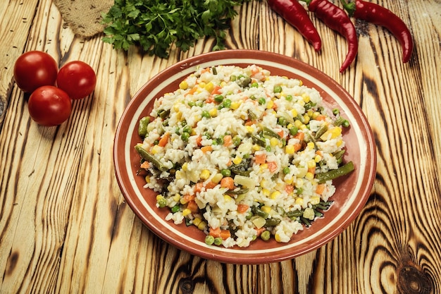 Apetitoso plato saludable de pasta orzo o risotto de arroz con verduras sobre un fondo de madera