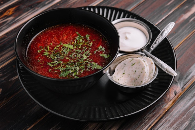 Apetitoso prato borscht servido com fatias de banha de pão e creme azedo