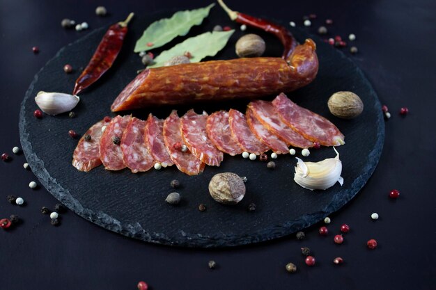 Apetitoso salami en rodajas sobre un paño de lino áspero y tomates cherry