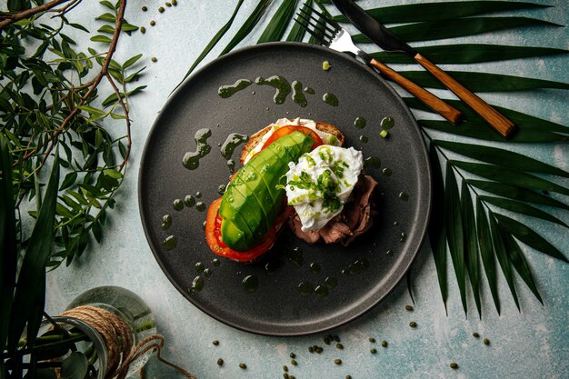 Apetitoso sándwich de aguacate con rosbif y huevo escalfado para el desayuno