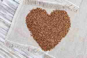 Foto apetitosos alforfones en forma de corazón. semillas de alforfón sobre fondo de madera con espacio de copia. alimentación saludable. estilo rústico