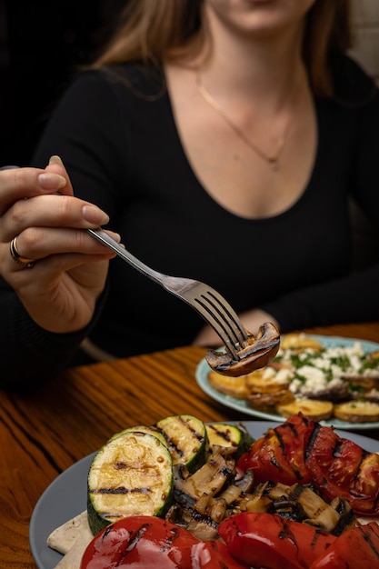 Foto apetitosos legumes grelhados em pratos sobre uma mesa de madeira escura