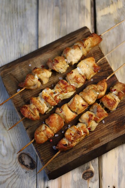 Apetitosos mini kebabs en una tabla de madera.