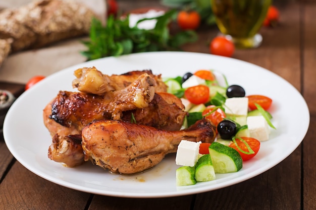 Apetitosos muslos de pollo dorado al horno y ensalada griega