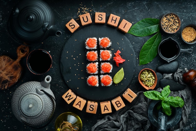 Apetitosos rollos de sushi con pescado y caviar en un plato de piedra negra. Cocina japonesa. Vista superior.