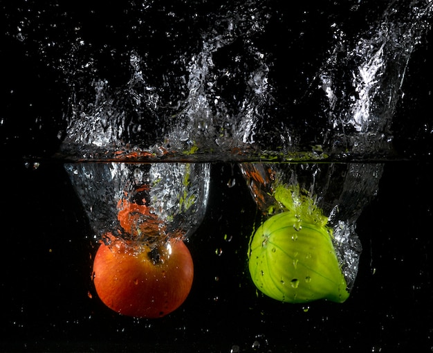 Apfel und Feigenkaktus spritzen ins Wasser