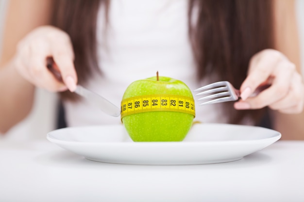 Apfel und Maßband auf dem Teller.