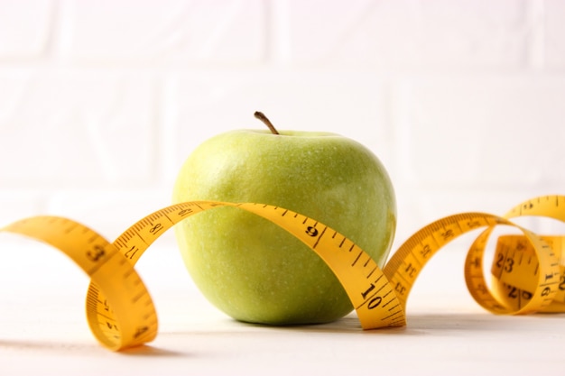 Apfel und Maßband Nahaufnahme auf hellem Hintergrund