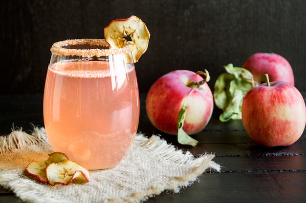 Apfel-Zimt-Cocktail auf schwarzem hintergrund.