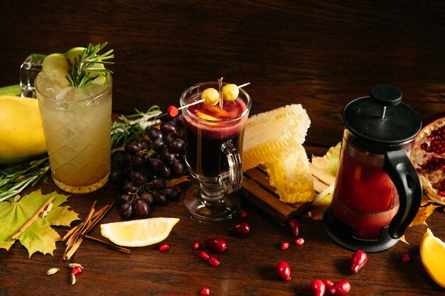 Apfelcocktail mit Rosmarin, Glühwein mit Beeren, Zitrone, Honig und Granatapfeltee in französischer Presse auf dem Tisch im Restaurant