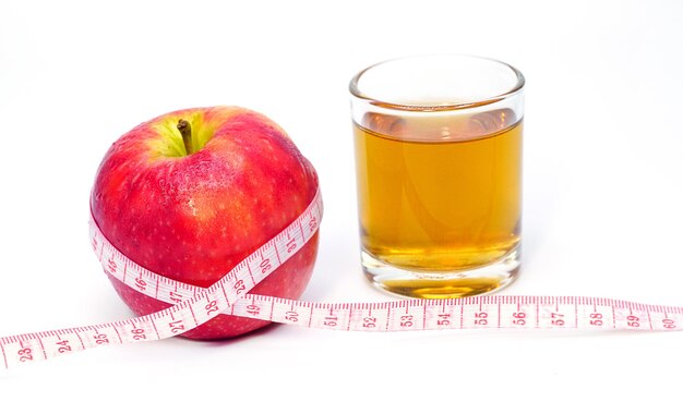 Apfelessig Apfel und Apfelsaft mit Maßband auf weißem Hintergrund gesundes Essen Getränk