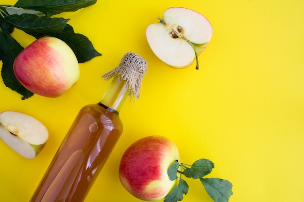 Apfelessig Apfelwein in der Glasflasche auf gelb