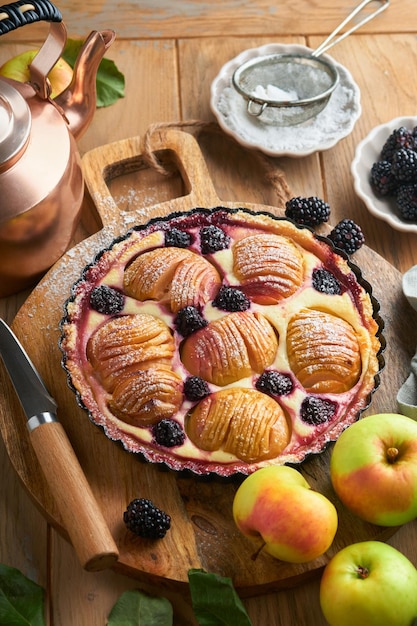 Apfelkuchen Apfel- und Brombeerkuchen oder Torte dekoriert Zuckerpulver auf alten Holztisch Köstliches Dessert für Herbst- oder Winterabendessen Herbstgebäck-Dessert Weichzeichner