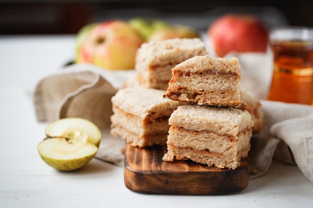 Apfelkuchen auf Holzbrett mit Tee in Beigetönen