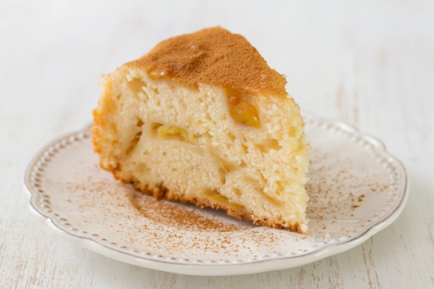 Apfelkuchen auf weißer Platte auf weißem hölzernem