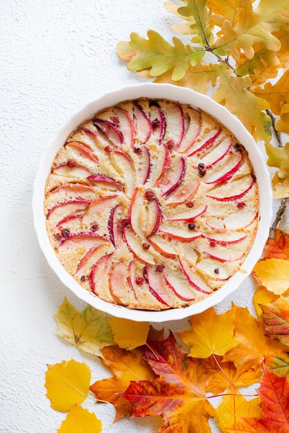 Apfelkuchen-Layout und Herbstlaub Draufsicht. Ein Artikel über den Herbst. Ein Artikel zum Thema Backen. Hausgemachte Kuchen.