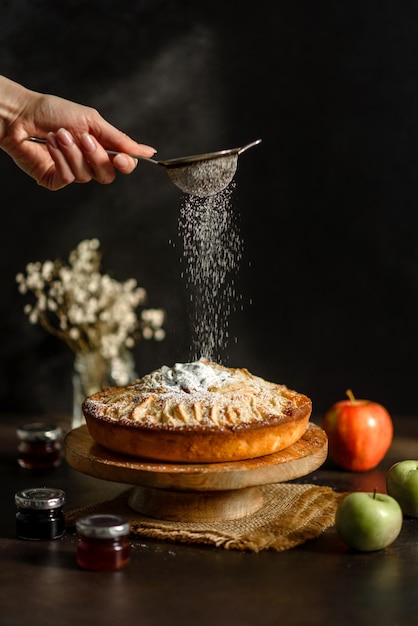 Apfelkuchen mit frischen Früchten auf einem Holztisch