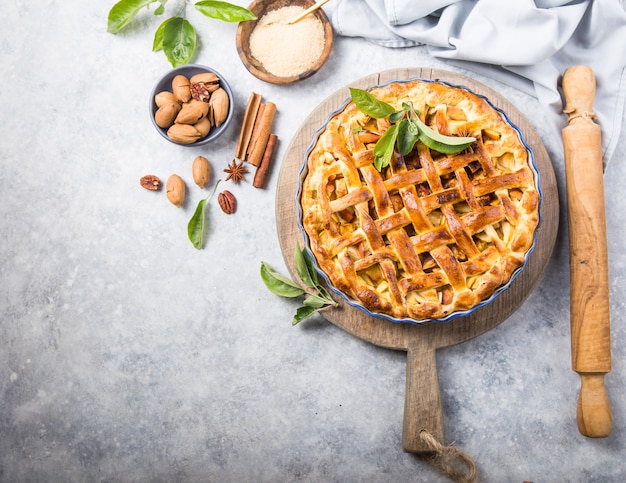 Apfelkuchen mit Salatplatte auf Holztisch, Tischoberansicht. Rustikaler amerikanischer Küchenkuchen