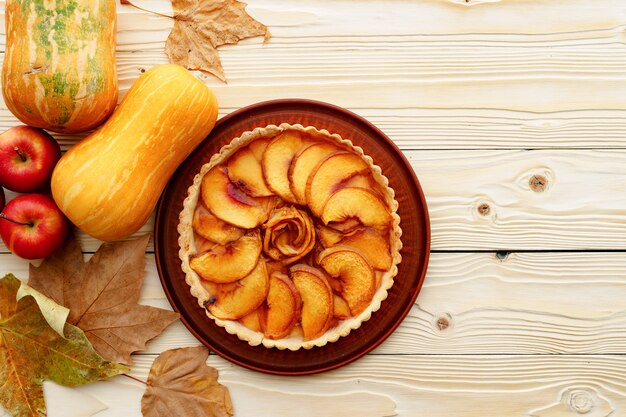 Apfelkuchen Torte auf Tisch mit Kürbis und trockenen Blättern