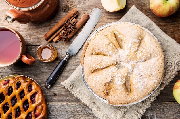 Apfelkuchen und Zutaten auf Holz