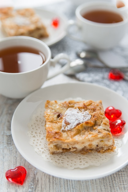 Apfelkuchenstücke mit Tassen Tee