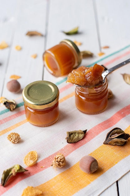 Apfelmarmelade in einem Löffel auf einem Glas Stoff heller Hintergrund Marmelade orange Birne Biokost Konzept und vegetarische dessertxA