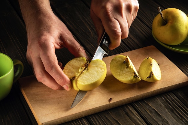 Apfelmarmelade zu Hause machen Hände eines Kochs mit einem Messer, das frische Äpfel auf einem Schneidebrett schneidet Fruchtdiät für eine Reihe von Vitaminen