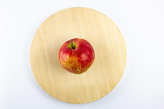 Apfelrot natürlich auf einer hölzernen Untertasse Frischer roter Apfel in einer Holzplatte