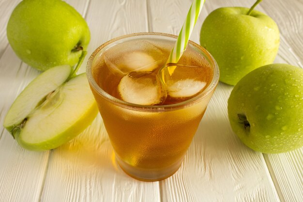 Apfelsaft im Glas auf dem weißen Holz