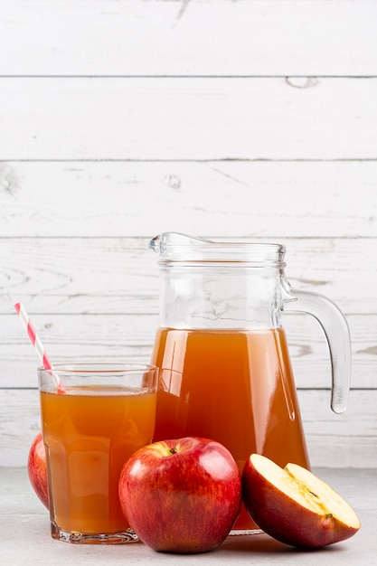 Apfelsaft und rote Äpfel auf dem Tisch.