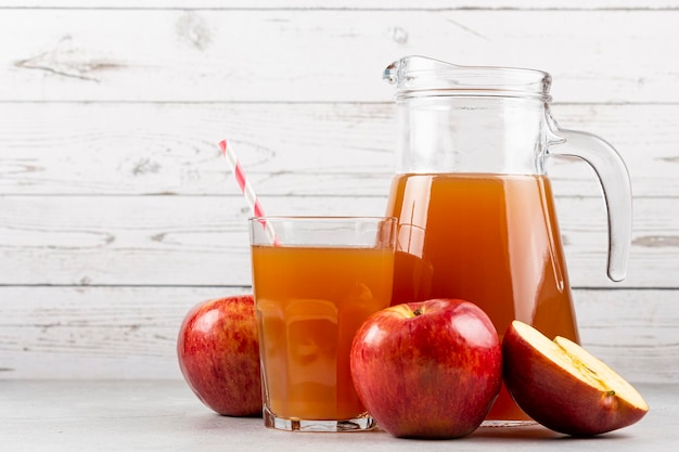 Apfelsaft und rote Äpfel auf dem Tisch.