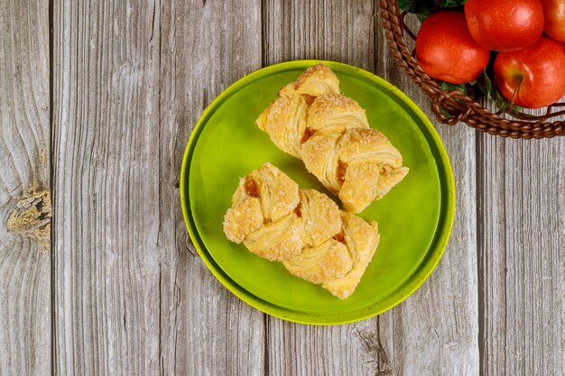 Apfelstrudel mit frischen roten Äpfeln auf Holztisch