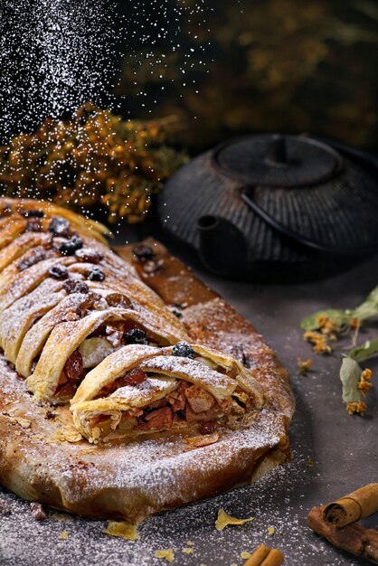 Apfelstrudel mit Puderzucker und Teekanne