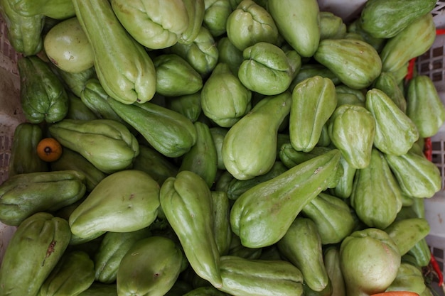 Foto apila verduras chayote verdes en una canasta en una foto de stock de un mercado tradicional