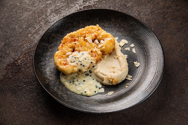 Apio nabo al horno con sal y verduras de cebolla en un plato sobre un fondo oscuro