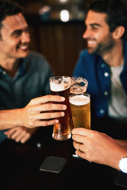 Foto aplausos de cerveja e mãos de homem bebendo com amigos em evento social em um restaurante com felicidade copos de álcool e brinde em um pub no happy hour com sorriso e conversa com bebidas e celebração