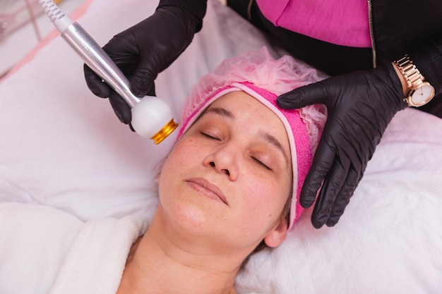 Aplicação de radiofrequência facial de mulher adulta bonita no tratamento de cuidados com a pele de rejuvenescimento do paciente