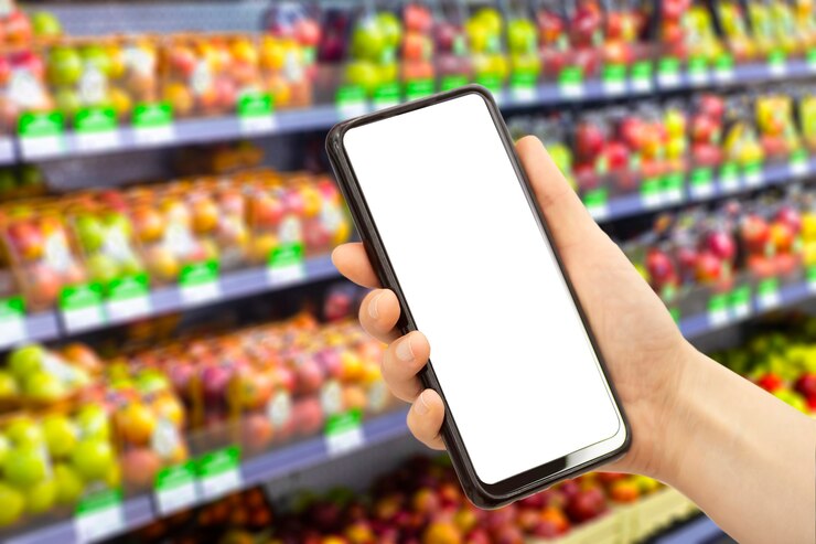Foto aplicación de entrega de comestibles en línea en un teléfono móvil. servicio de mercado de alimentos en smartphone. carrito de compras. pantalla en blanco vacía.