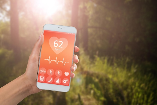 Aplicación especial del concepto de monitoreo de la salud en el teléfono inteligente en un fondo de paisaje al aire libre de la mano
