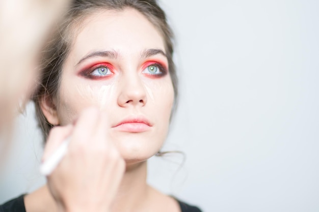 Aplicación de maquillaje de corrector de base Primer plano