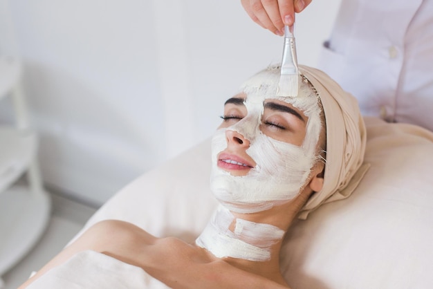 Aplicación de máscara facial orgánica de belleza spa en el salón de spa de día.