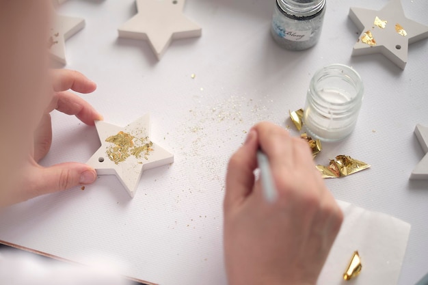 Foto aplicación de la mujer de la hoja de oro el artista decora el concepto de hobby y creatividad de la artesanía de yeso de oro