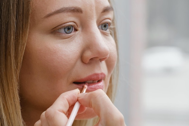 Aplicando maquiagem labial closeup do rosto de mulher com